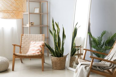 Şık oda içinde rahat koltuklar ve ayna.