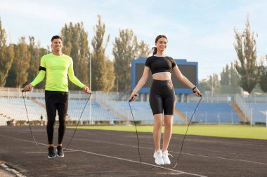 Stadyumda ip atlama antrenmanı yapan genç bir çift.