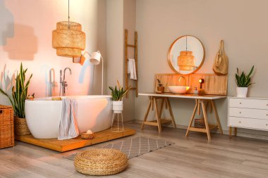 Akşamları masa, lavabo ve ev bitkileriyle modern banyo.