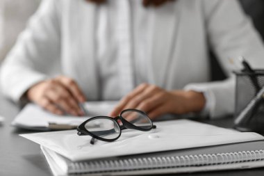 Ofisteki masada klasörlü gözlük, yakın plan.