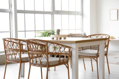 Masa, kanepe ve büyük pencereli hafif yemek odasının içi.