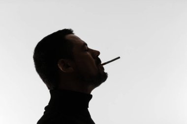 Hafif arkaplanda sigara içen adamın silüeti