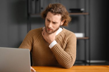 Ofiste boğazı ağrıyan hasta bir adam.