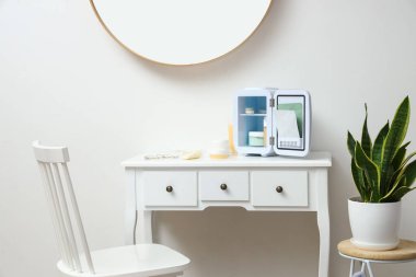 Odadaki küçük kozmetik buzdolabı.