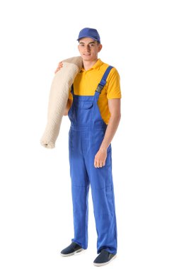 Beyaz arka planda rulo halı olan erkek işçi.