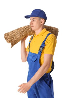 Beyaz arka planda rulo halı olan erkek işçi.