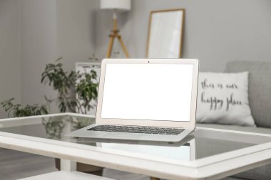 Odadaki cam masada modern bir dizüstü bilgisayar.