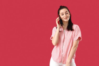 Renkli arka planda cep telefonuyla konuşan güzel kız öğrencinin portresi