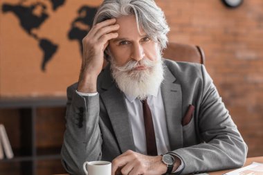 Yakışıklı, sakallı iş adamı.