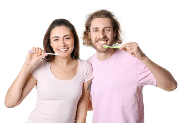 Beyaz arka planda dişlerini fırçalayan mutlu genç çift