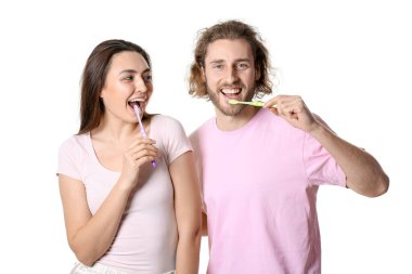 Beyaz arka planda dişlerini fırçalayan mutlu genç çift