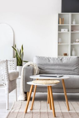 Oturma odasındaki kanepenin yanındaki modern dizüstü bilgisayarlı masa.