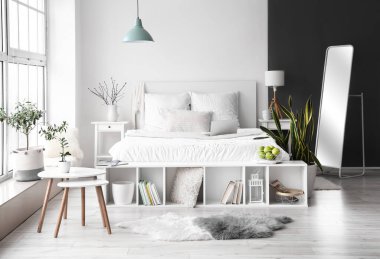 Konforlu yatak odası ve modern dizüstü bilgisayarı olan şık bir iç mekan.