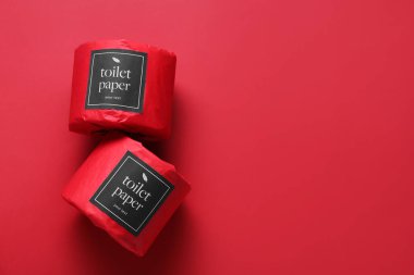 Kırmızı arka planda tuvalet kağıdı ruloları