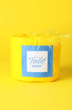 Sarı arka planda tuvalet kağıdı rulosu