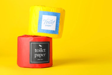 Sarı arka planda tuvalet kağıdı ruloları