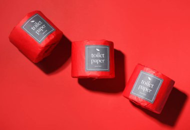 Kırmızı arka planda tuvalet kağıdı ruloları