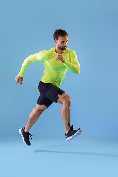 Sporty male runner on color background