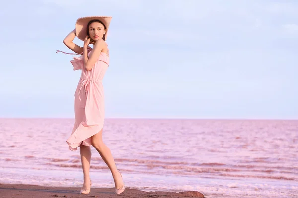 夏の日にピンクの湖の近くにポーズスタイリッシュな若い女性 — ストック写真