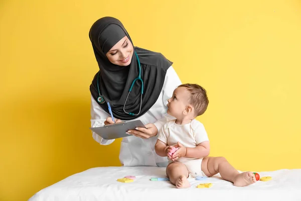 Pediatra Musulmán Examinando Niño Sobre Fondo Color — Foto de Stock