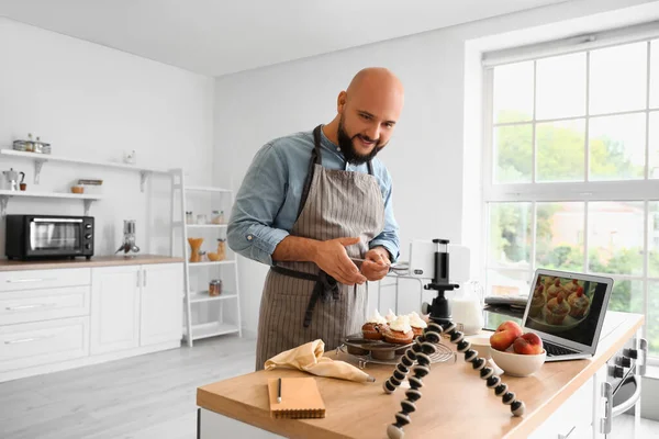 Yakışıklı Adam Mutfaktaki Şeftalili Keklerin Üzerine Şeker Serpiyor — Stok fotoğraf