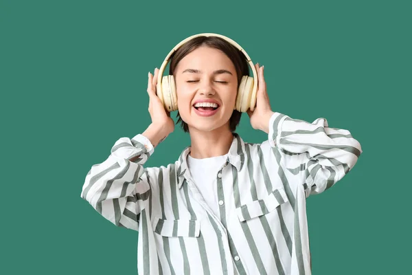 Hermosa Joven Escuchando Música Sobre Fondo Verde —  Fotos de Stock