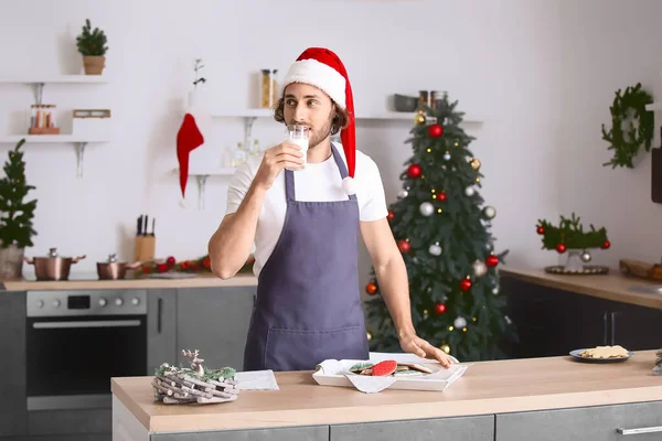 Young Man Santa Hat Drinking Milk Christmas Cookies Home — Stock Photo, Image