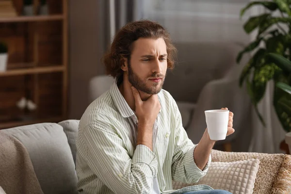 喉が痛い男飲み熱いお茶で家 — ストック写真