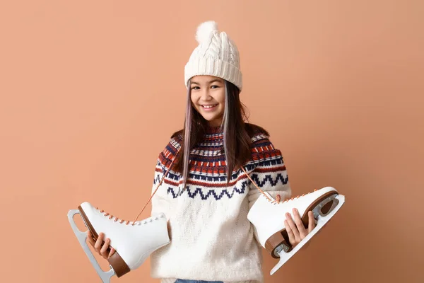 小さなアジアの女の子で暖かいです服とともにアイススケート上のベージュの背景 — ストック写真
