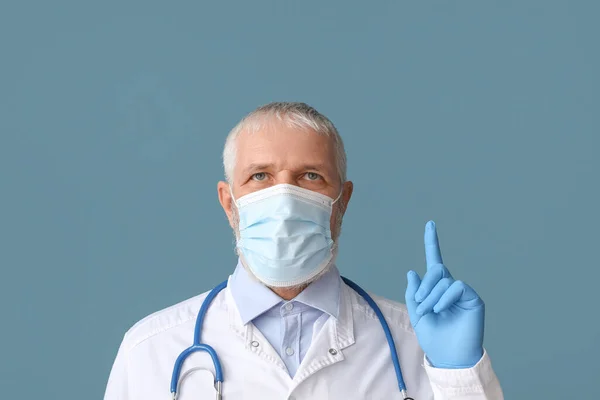 Mature Male Doctor Medical Mask Stethoscope Pointing Something Blue Background — Stock Photo, Image