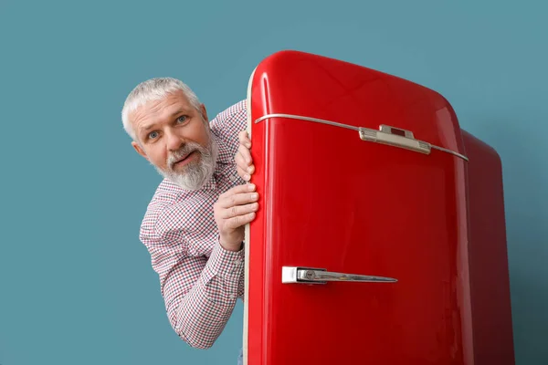 Älterer Mann Und Roter Kühlschrank Auf Blauem Hintergrund — Stockfoto