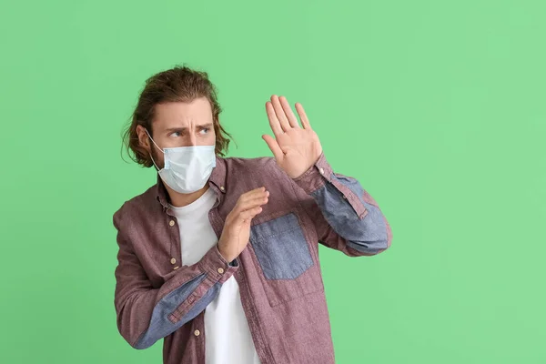 Φοβισμένος Νεαρός Άνδρας Φορώντας Ιατρική Μάσκα Στο Φόντο Χρώμα — Φωτογραφία Αρχείου
