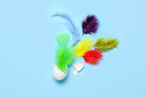 Composition Broken Egg Colorful Feathers Blue Background — Stock Photo, Image