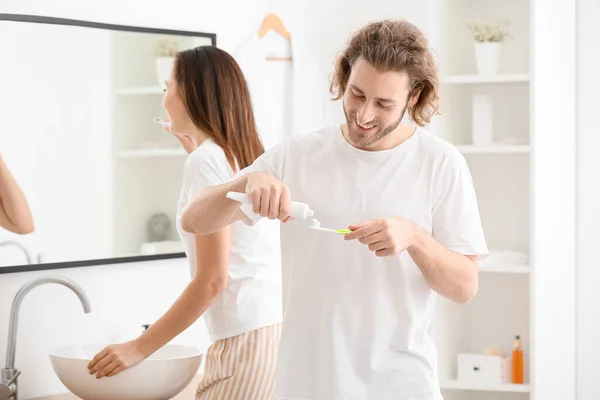 Junger Mann Trägt Zahnpasta Auf Bürste Badezimmer Auf — Stockfoto