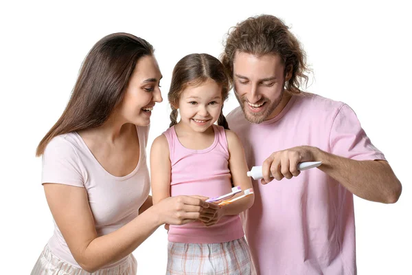 若い男は白い背景に彼の妻と娘のブラシに歯磨き粉を適用する — ストック写真