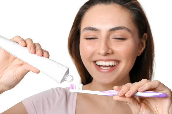 Mujer Joven Aplicando Pasta Dental Sobre Cepillo Sobre Fondo Blanco — Foto de Stock