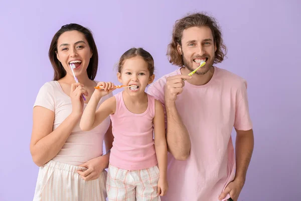 Menina Com Pais Escovando Dentes Fundo Lilás — Fotografia de Stock