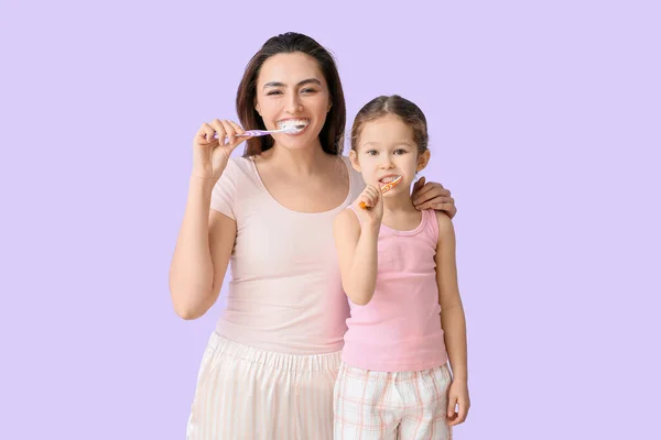 Niña Con Madre Cepillándose Los Dientes Sobre Fondo Lila —  Fotos de Stock