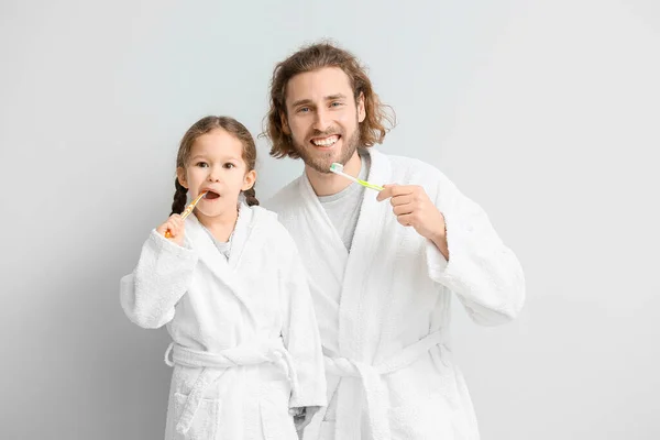 Küçük Bir Kız Babası Arka Planda Dişlerini Fırçalıyorlar — Stok fotoğraf