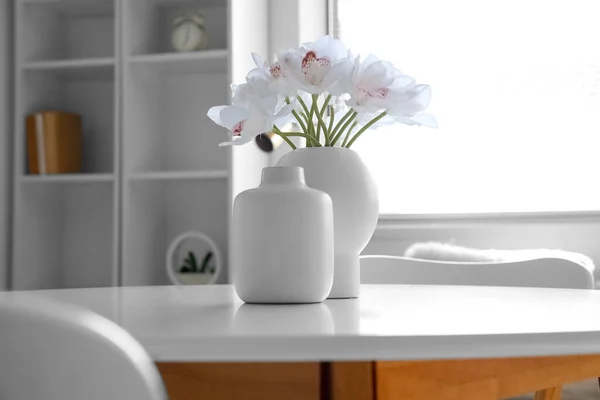 部屋の白いテーブルの上の花瓶や美しい蘭の花 — ストック写真