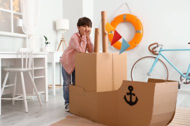 Sevimli küçük çocuk evde karton gemi ile oynamak