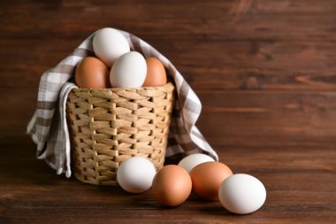 Tahta arka planda taze tavuk yumurtaları olan sepet.