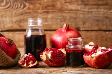 Kavanozlar dolusu nar pekmez ve ahşap zemin üzerinde taze meyveler.