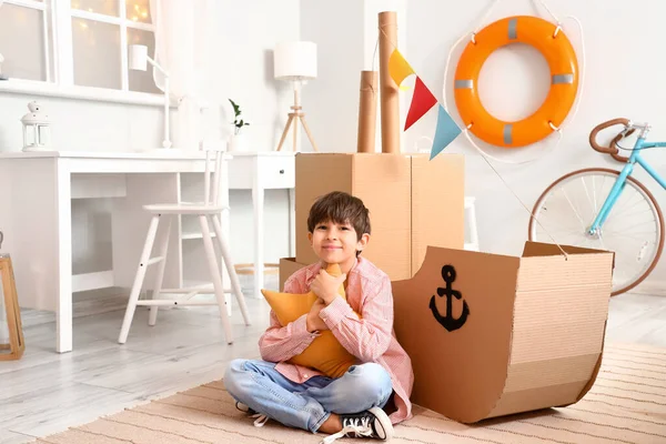 Sevimli küçük çocuk evde karton gemi ile oynamak