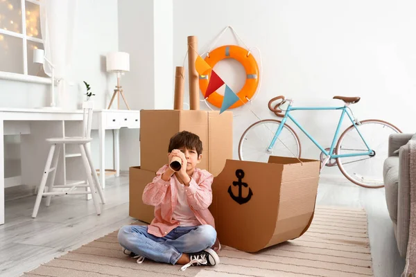 Sevimli küçük çocuk evde karton gemi ile oynamak