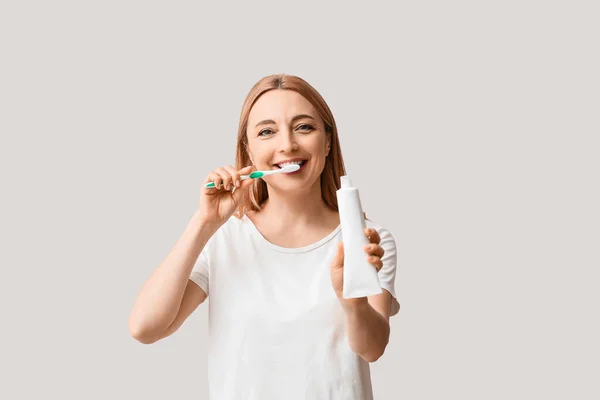 Beautiful Mature Woman Brushing Teeth Light Background — Stock Photo, Image