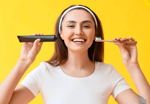 Mulher Bonita Com Pasta Carvão Ativado Dente Escova Fundo Amarelo — Fotografia de Stock