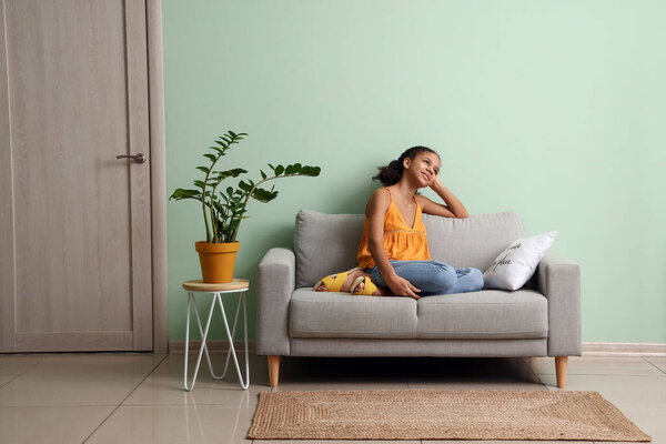 African-American teenage girl relaxing on sofa at home