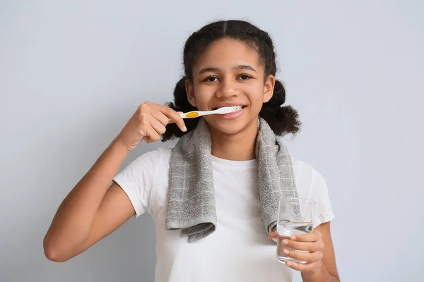 Afroamerikansk Tonåring Flicka Med Glas Vatten Borsta Tänderna Ljus Bakgrund — Stockfoto