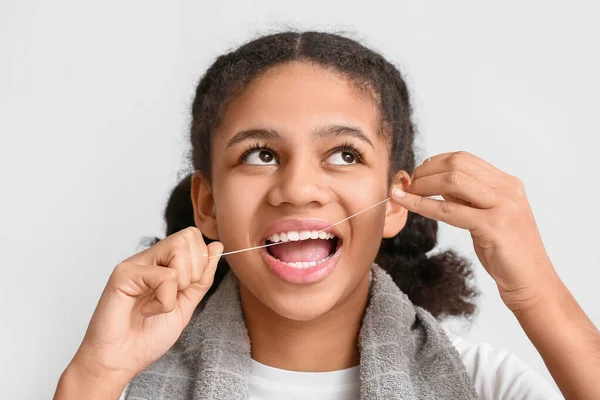 African American Teenage Girl Flossing Teeth Light Background — Stock Photo, Image
